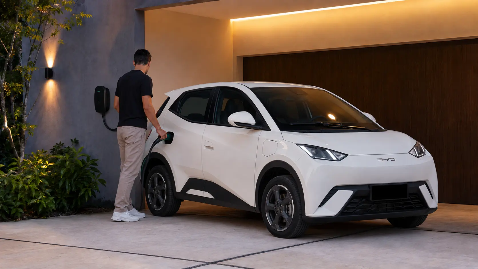 BYD Dolphin Mini azul conectado a um wallbox em garagem residencial